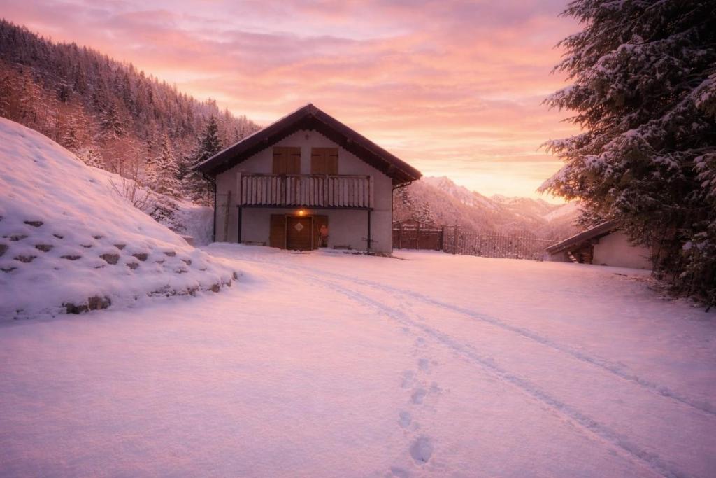 a cabin in the snow in front of a mountain at Baita dal Bigolaro in Vetriola
