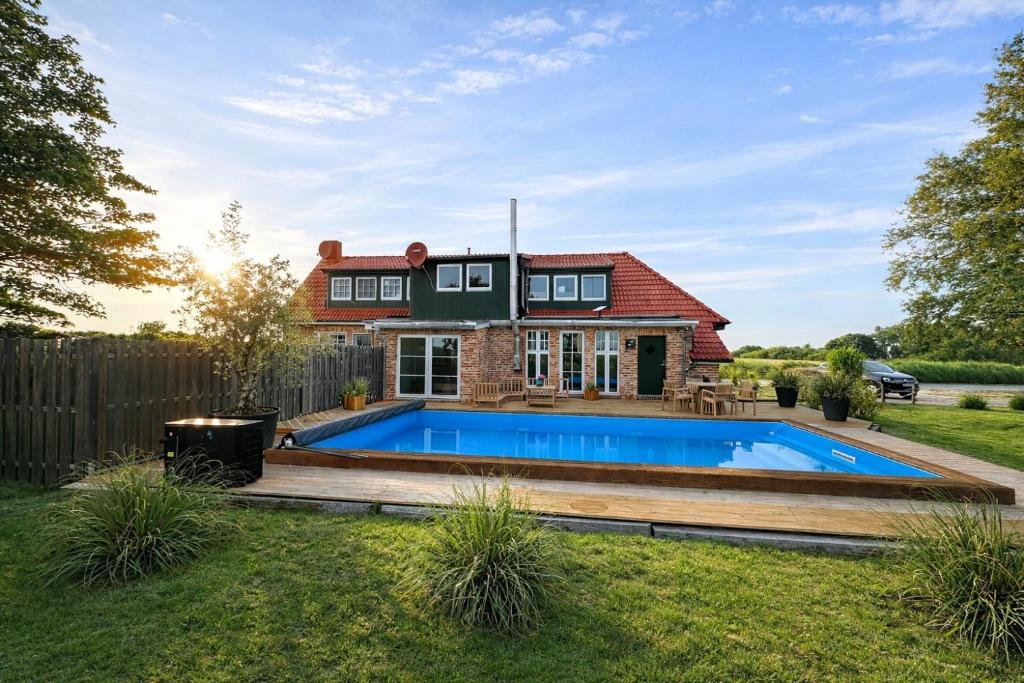 a house with a swimming pool in the yard at Ferienhaus 'Huus ant Diek mit Pool' in Norden