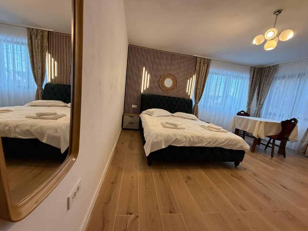 a bedroom with two beds and a mirror at Casa Romanța in Cehu Silvaniei