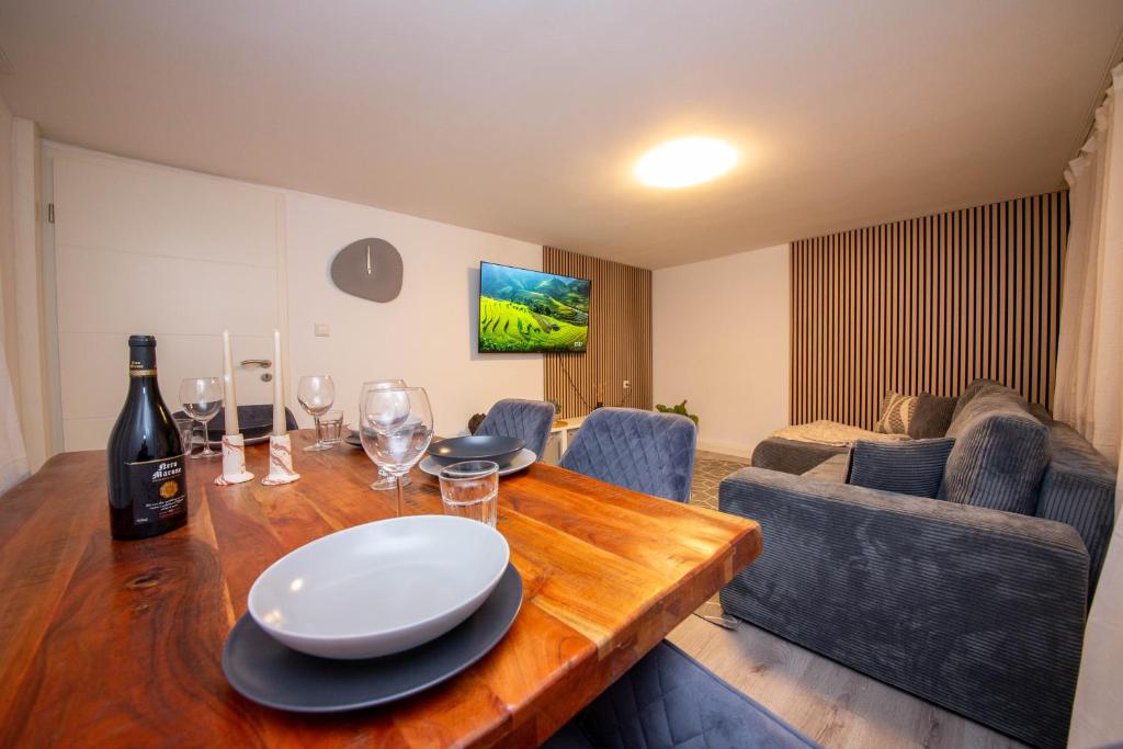 a dining room with a wooden table and wine glasses at Mimi's Home in Dußlingen