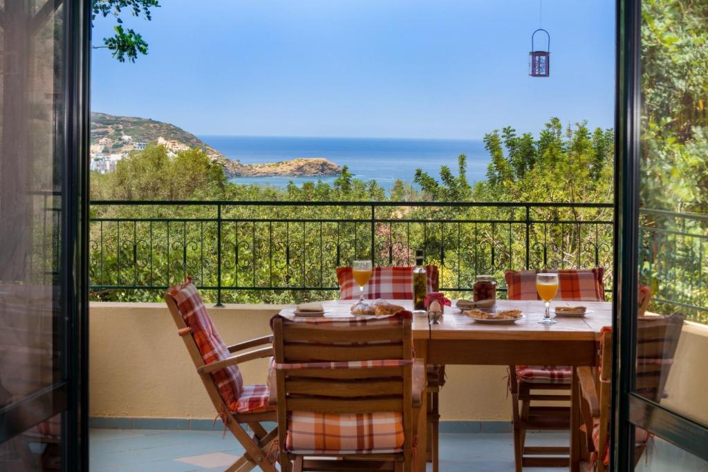 a table and chairs on a balcony with a view of the ocean at Villa Apelia - Family Holidays Deals in Vlikhádha
