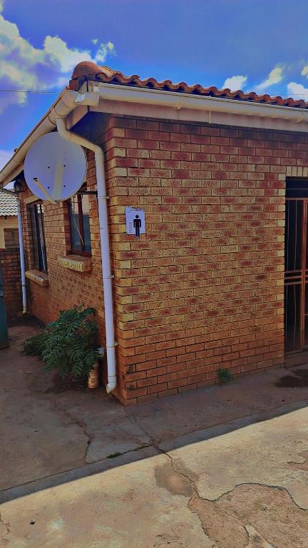 a red brick building with a satellite at Tetelos house in Cullinan