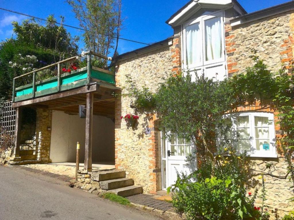 a brick house with a balcony on the front of it at Finest Retreats - Little Roost in Lyme Regis