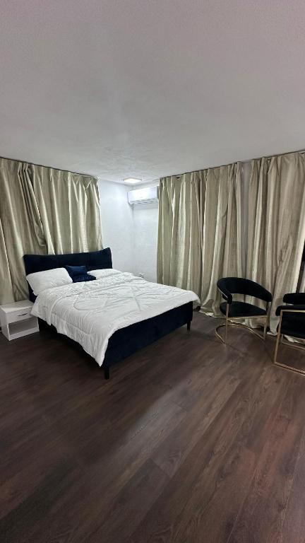 a bedroom with a bed and two chairs in it at APARTMANI Sarajevo in SJJ