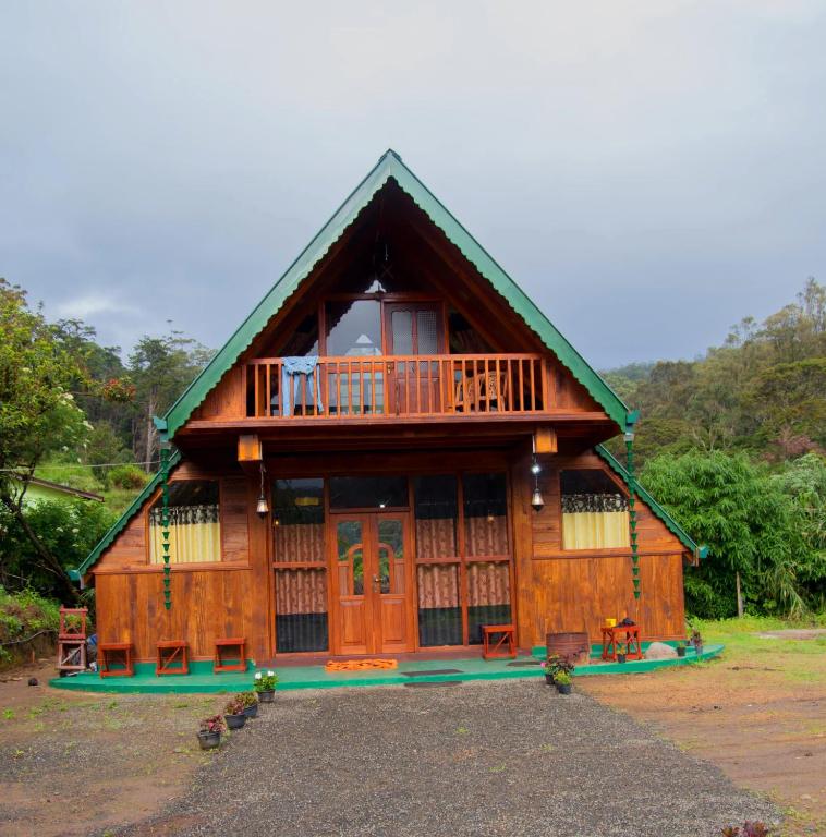 a large wooden house with a balcony at Ohiya Our Time Kabana in Ohiya