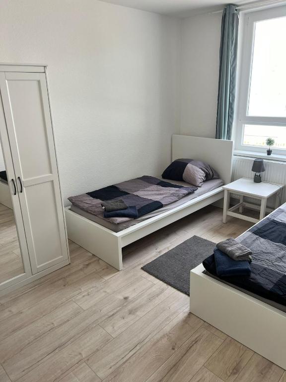 a white bedroom with a bed and a mirror at Nord & Feld Kajüte in Bremerhaven