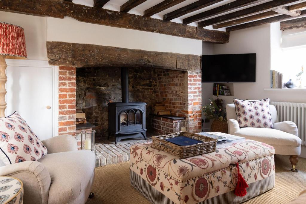 a living room with a fireplace and a couch and chairs at The Nook by The Butler Collection in Petworth