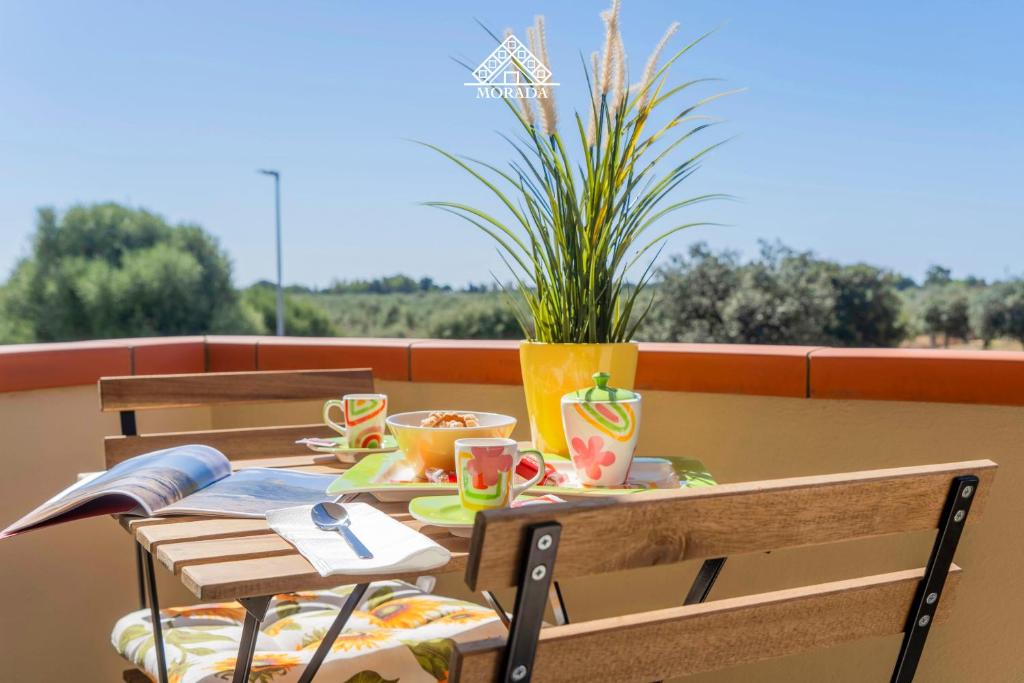 a table with cups and chairs on a balcony at Casa Torre di Nora - Morada in Pula