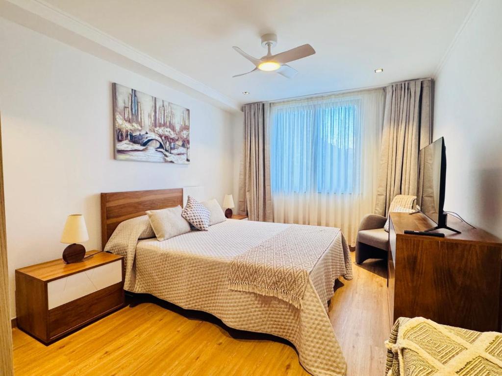 a bedroom with a bed and a flat screen tv at Bela Vista Studio in Ponta Delgada