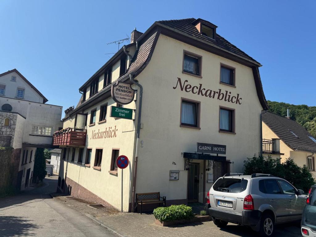 a building with a car parked in front of it at Hotel Garni Neckarblick in Neckarsteinach