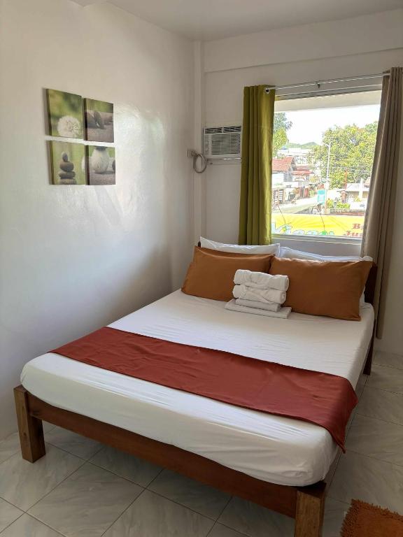 ein großes Bett in einem Zimmer mit Fenster in der Unterkunft Leonardo Hostel in Anda