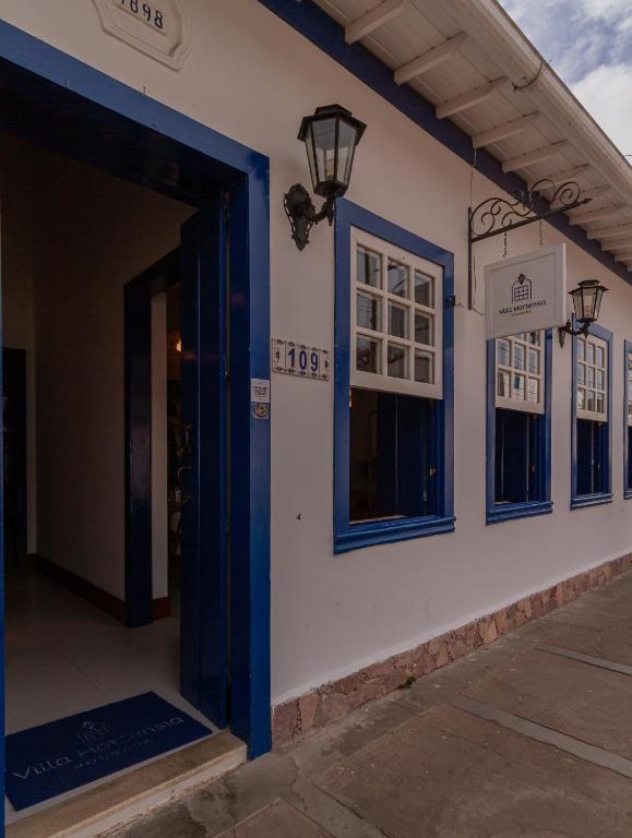 a building with a blue door and windows at Villa Hortensia in Mucugê