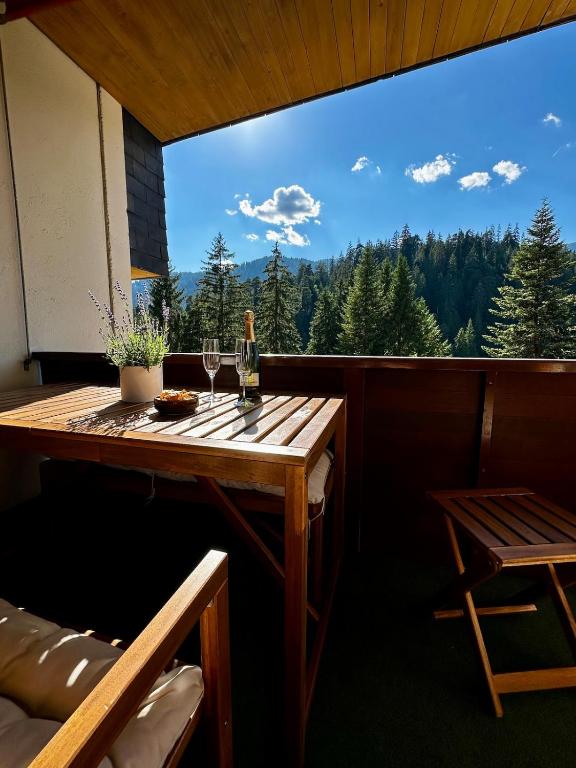 a table with two glasses of wine on a balcony at HappyLaax - Panoramic Penthouse - Pool, Sauna & Private Parking in Laax