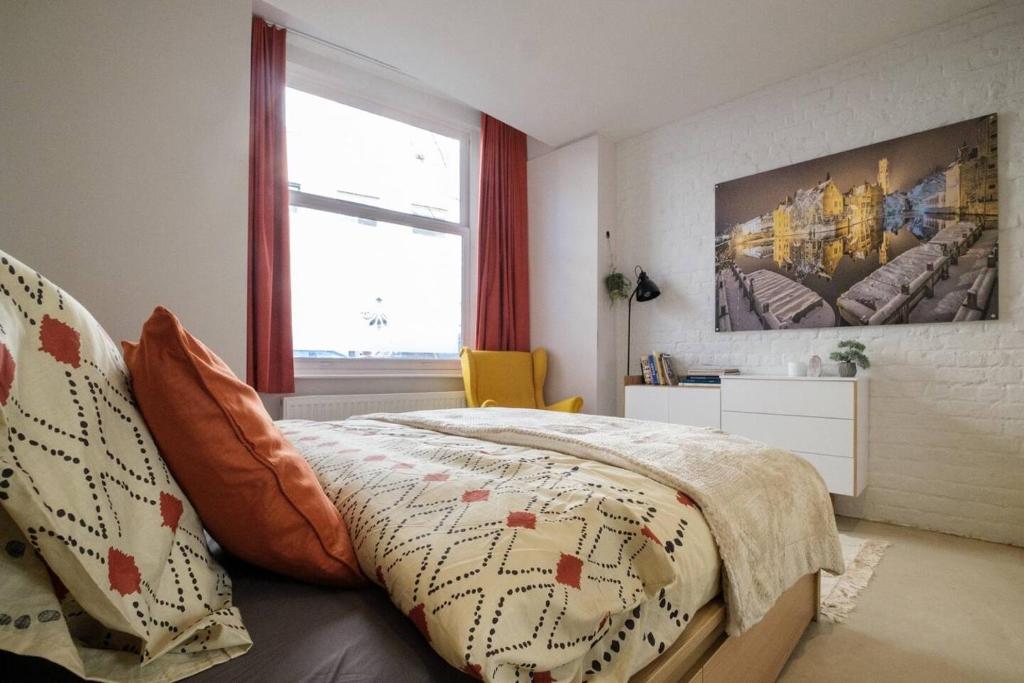 a bedroom with a bed and a painting on the wall at Maison Bonheur in Bruges