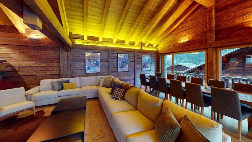 a living room with a couch and tables and chairs at Chalet Chavanette - Beautiful 7 bedrooms Chalet in Champéry