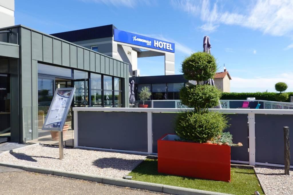 a hotel with a sign in front of a building at The Originals City, Hôtel Hélios, Roanne Nord in Mably