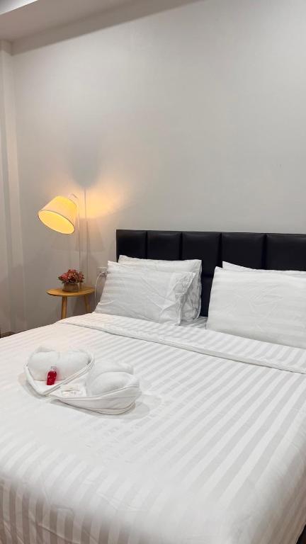 a white bed with two white plates on it at สังข์เงินรีสอร์ท2 in Nakhon Sawan