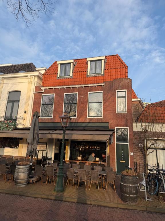 a building with tables and chairs in front of it at Apartement hotel Stays by ADM in Leiden
