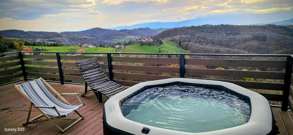 a hot tub and two chairs on a deck with a view at Vineyard cottage Mehak in Telče