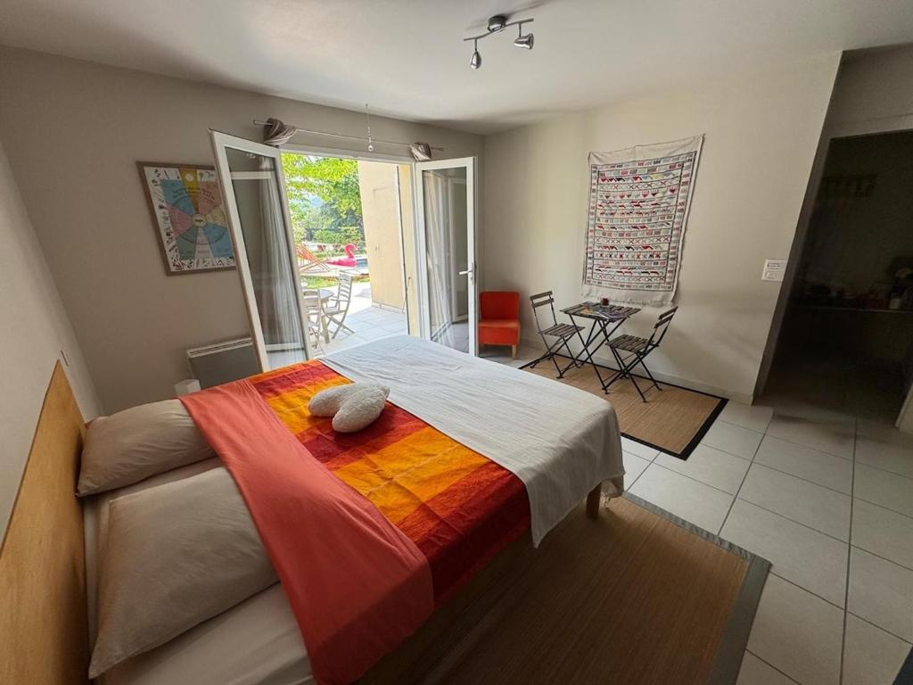 a bedroom with a bed with a colorful blanket at Studio Lumineux avec jardin & piscine à Vaison la Romaine in Vaison-la-Romaine
