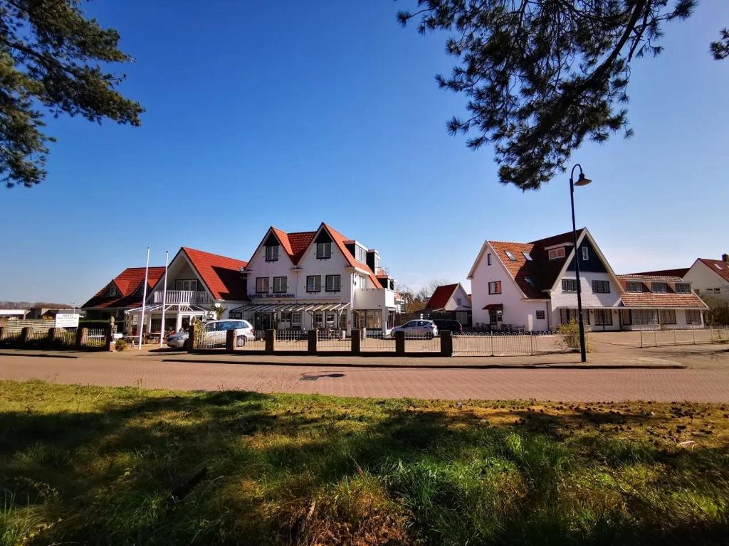 a row of houses in a residential neighborhood at Hotel het Uilenbos in De Koog