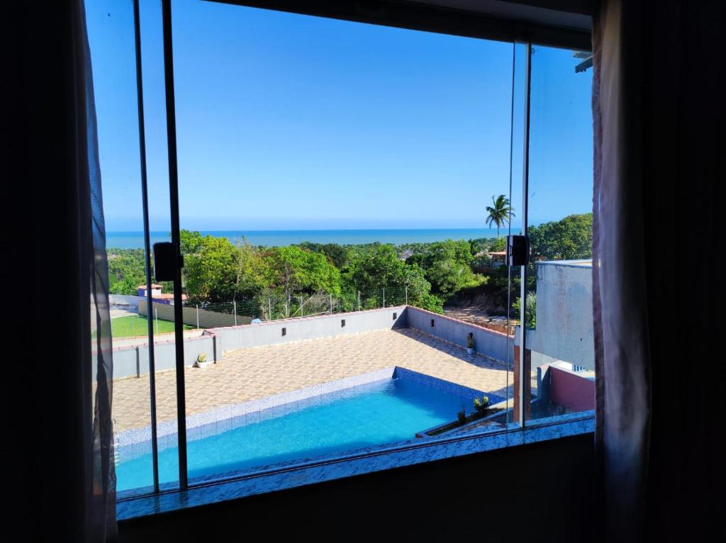 a view of a swimming pool from a window at Hostel Vista Mar in Porto Seguro