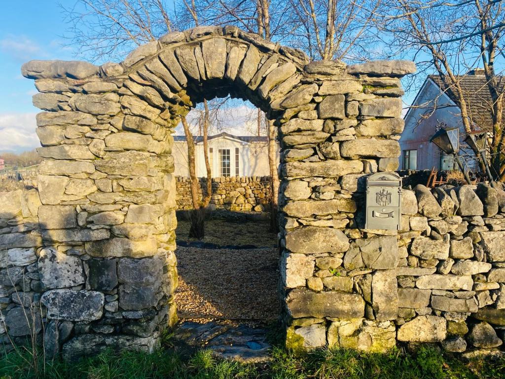 an archway in a stone wall in front of a house at Lakeside in Carrowmoreknock