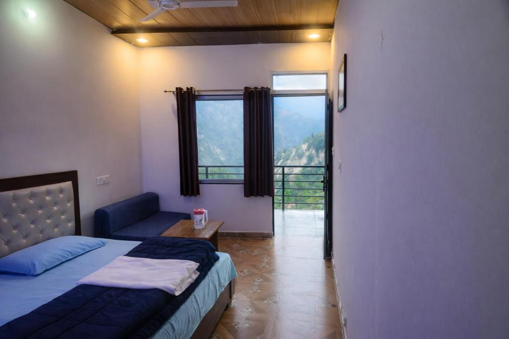 a bedroom with a bed and a couch and a window at shiv shankar resort and hotel in Phata