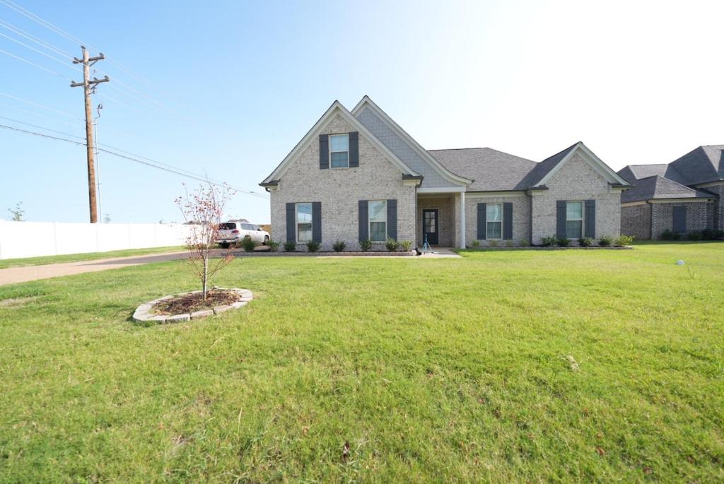 a house with a tree in the middle of a yard at Desoto Rental in Olive Branch