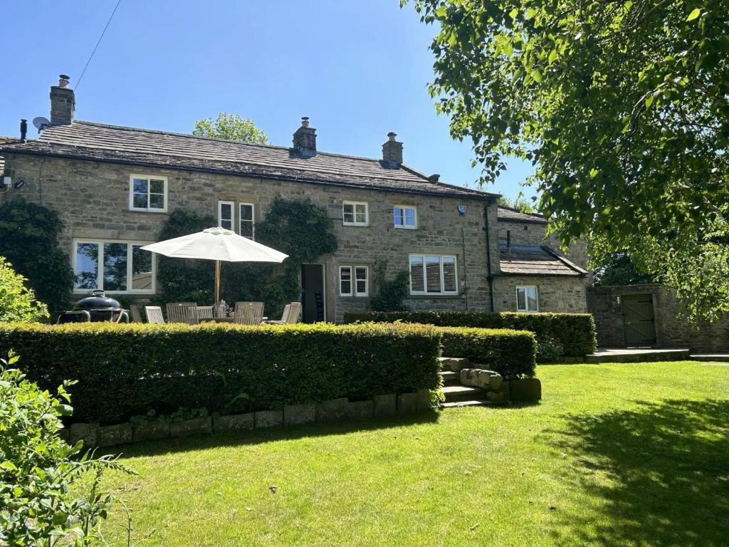 a house with an umbrella in front of a yard at 4 Bed in Middleham oc-c34754 in Caldbergh