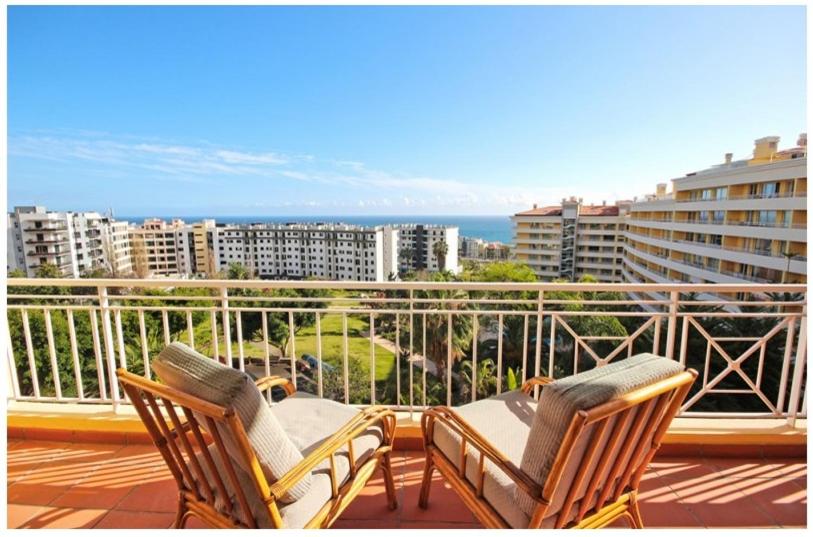 Duas cadeiras e uma mesa numa varanda com vista em Tulipa View Apartament no Funchal