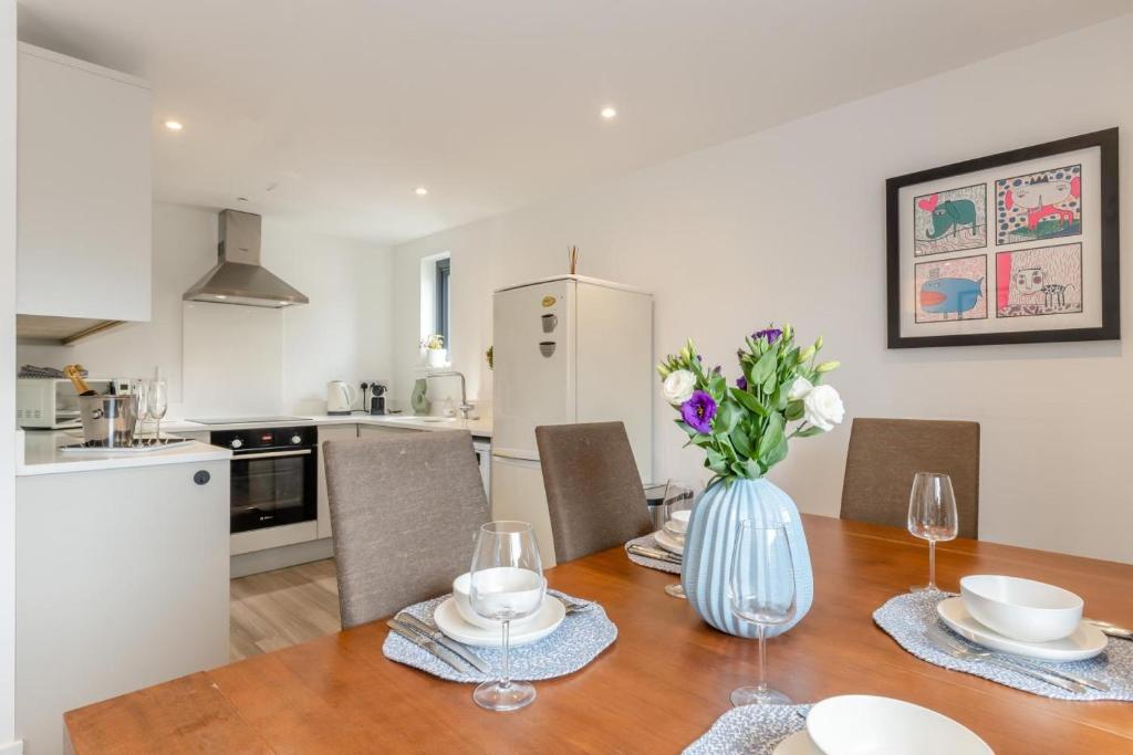 a kitchen and dining room with a table with a vase of flowers at 2 Bed in Holt oc-l31797 in Holt