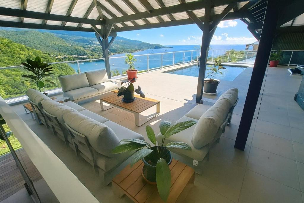 a living room with couches and a view of the ocean at Villa 4 étoiles Le Pic de Malendure in Bouillante