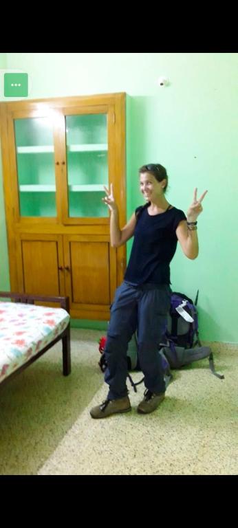 a woman standing in a room with her hands up at pondicherry hostel in Pondicherry