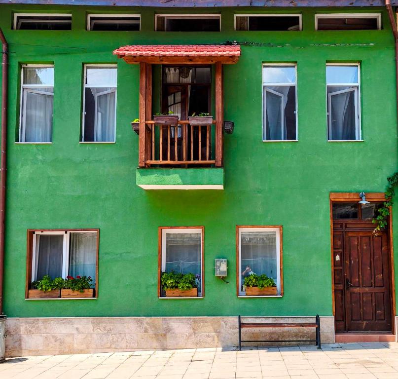 a green building with windows and a balcony at PORTALA Urban Lodge in Rila