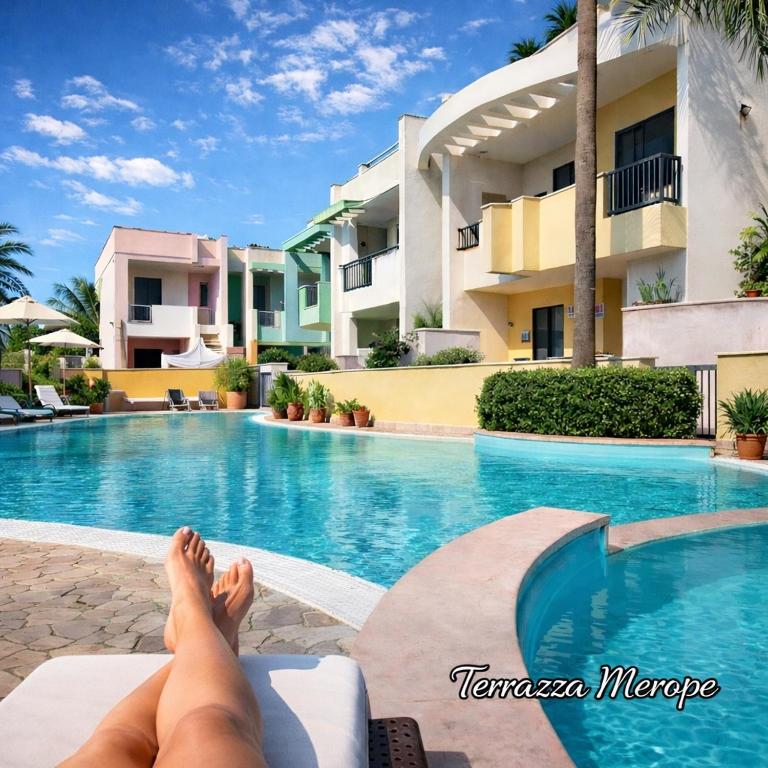 a person laying on a bed next to a swimming pool at Terrazza Merope in Torre dell'Orso