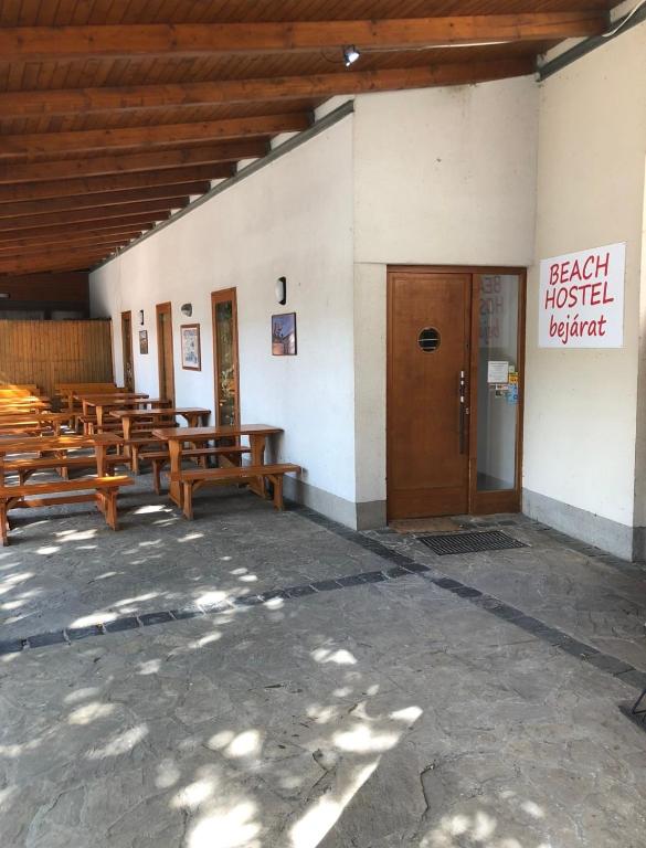 a group of wooden benches in a building at Beach Hostel Balatonboglár in Balatonboglár