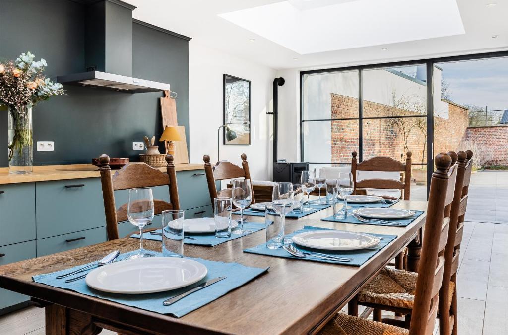 a dining room with a long wooden table with glasses at Butte du Lion in Genappe
