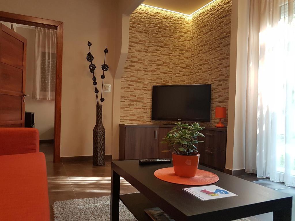 sala de estar con TV en una pared de ladrillo en MgTels Apartman - with private parking en Budapest