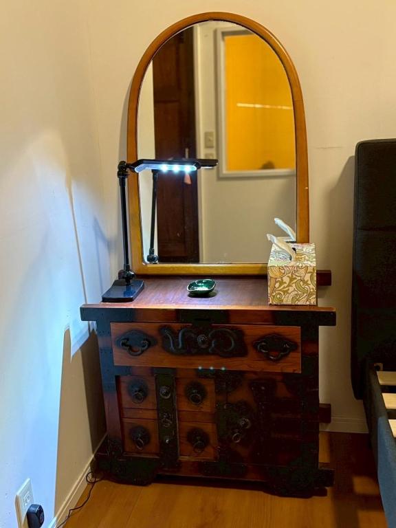a dresser with a mirror on top of it at Runbull House in Tokyo