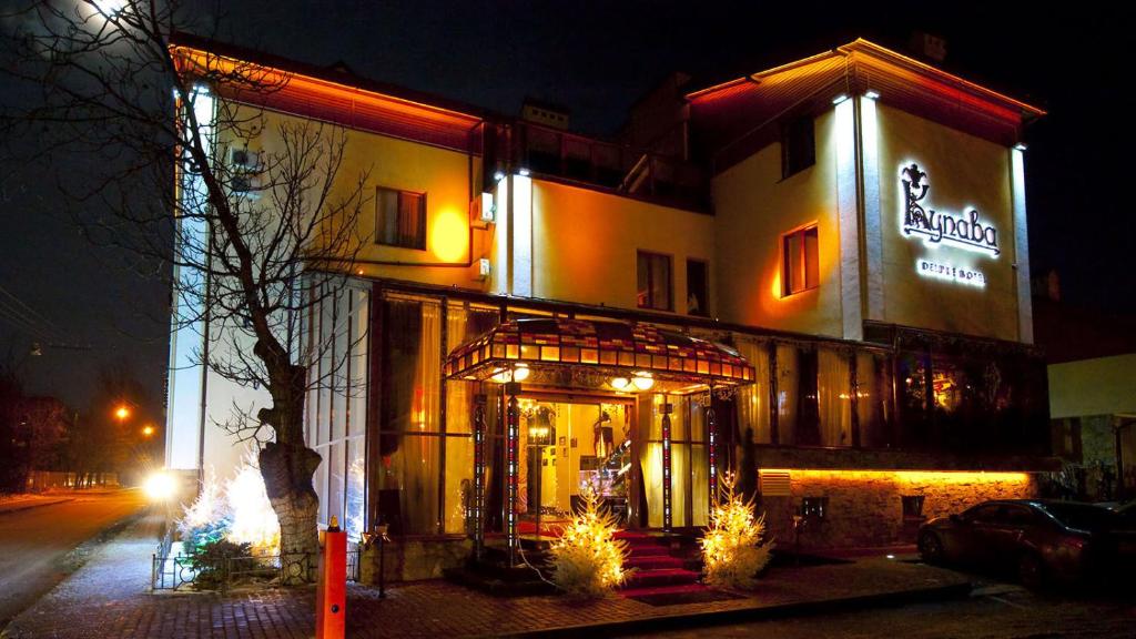 a building with a sign on the side of it at Deluxe Hotel Kupava in Lviv
