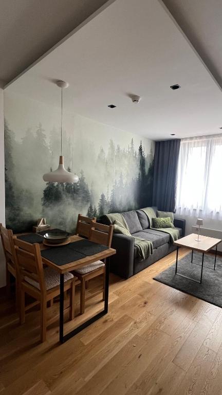 a living room with a couch and a table at Apartement LUNA Hotel Zlatni javor in Jahorina