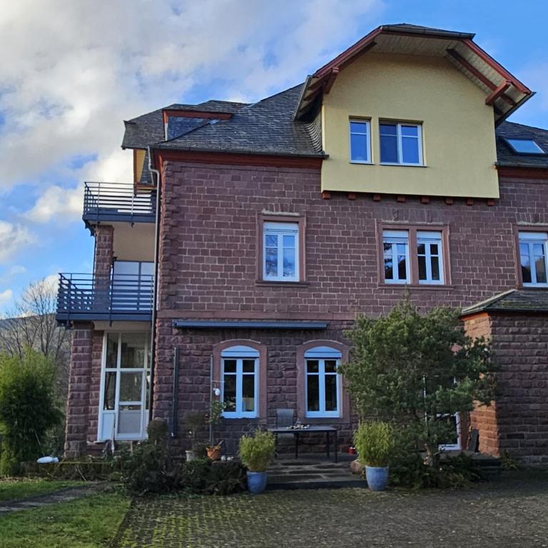 a large brick house with a balcony on it at Ferienwohnung Lucia Amorbach in Amorbach