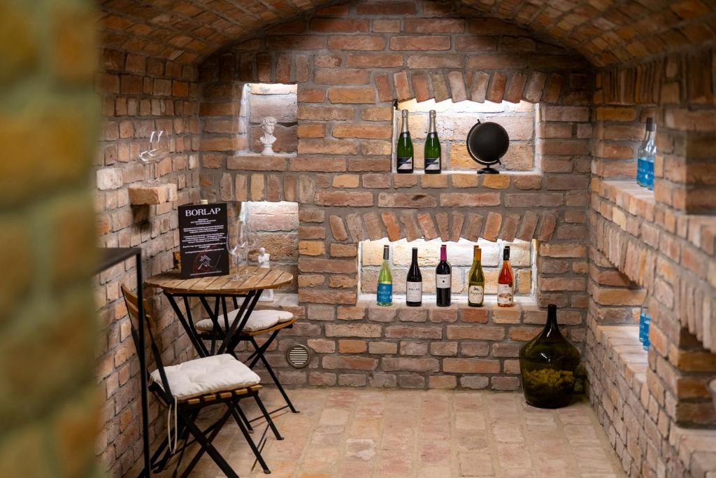 a room with bottles of wine on a brick wall at Volt Egyszer Egy Apartman Pécs in Pécs
