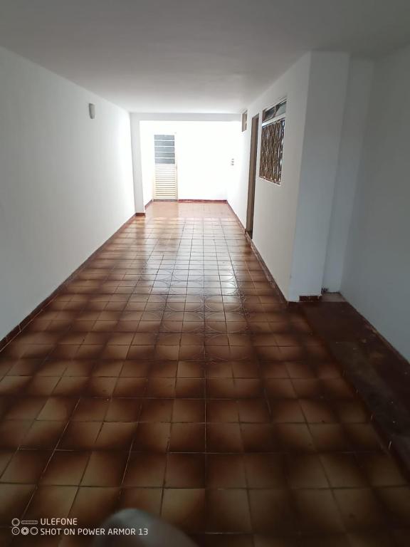 an empty hallway with a tile floor and white walls at Casa para 6 pessoas completa in Ribeirão Preto