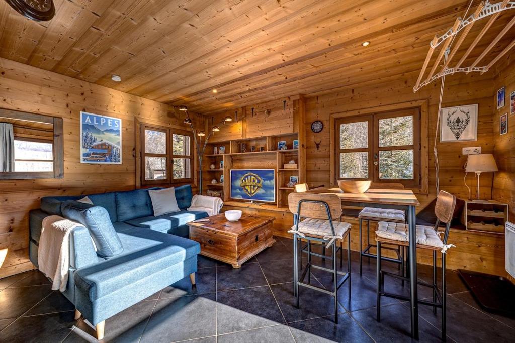 a living room with a blue couch and a table at Tiny Chalet - near to Servoz train station in Les Houches