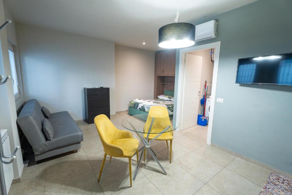 a living room with a table and chairs and a bed at La casa di Aurora in Pavia