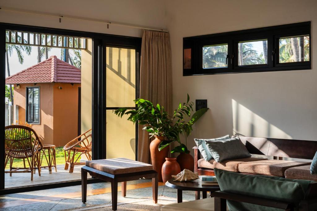 a living room with a couch and a patio at illa - By the sea in Udupi