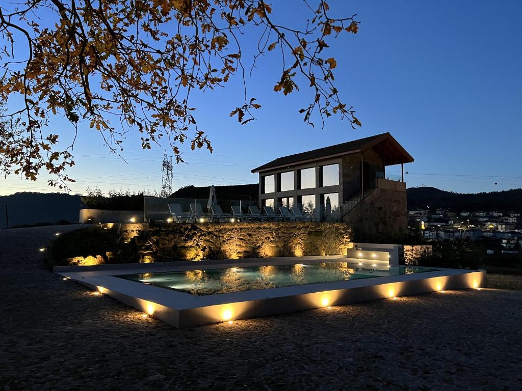 a pool with lights in front of a building at Casa da eira in Santo Emilião