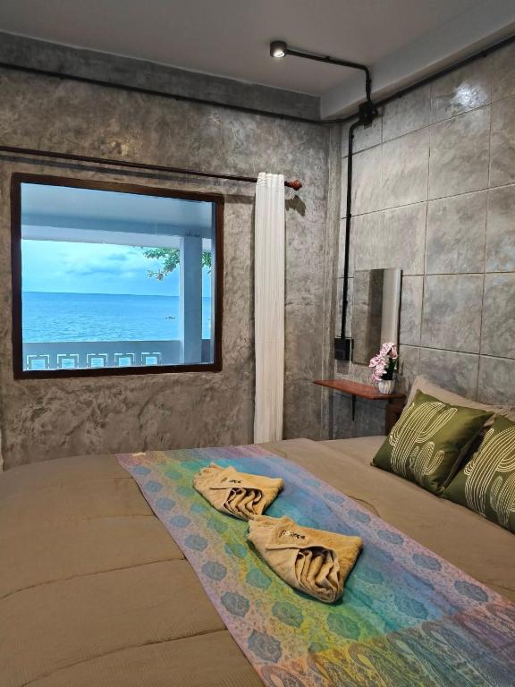 a bedroom with a bed with a large window at Libong haven in Ko Kwang